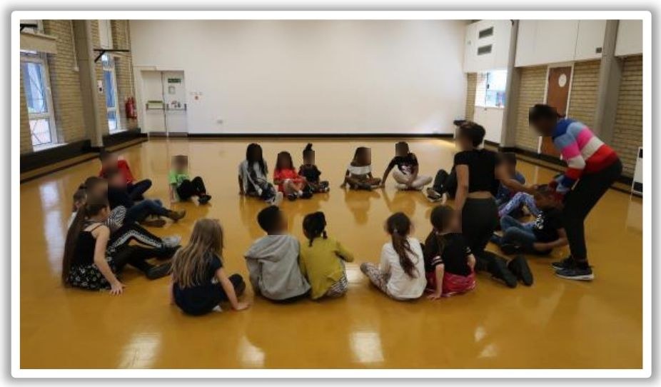 Children sitting in a circle during a drama session at the AFC Wimbledon Foundation summer programme